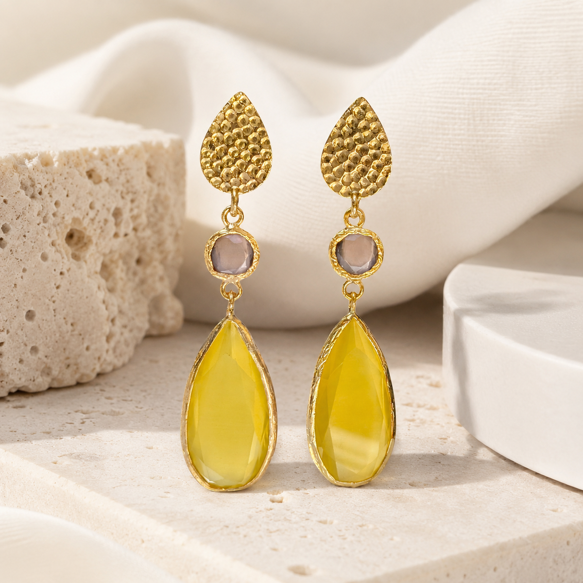 Front view of hammered gold-plated drop earrings with a teardrop silhouette and faceted accents.