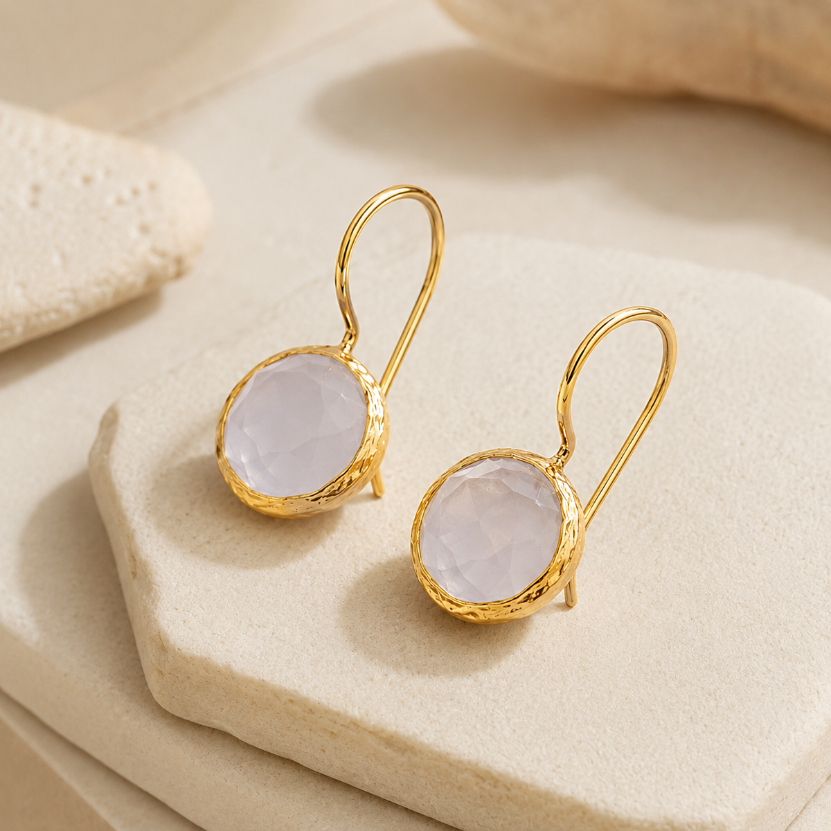 Angle view of moonstone drop earrings in a gold-plated setting.