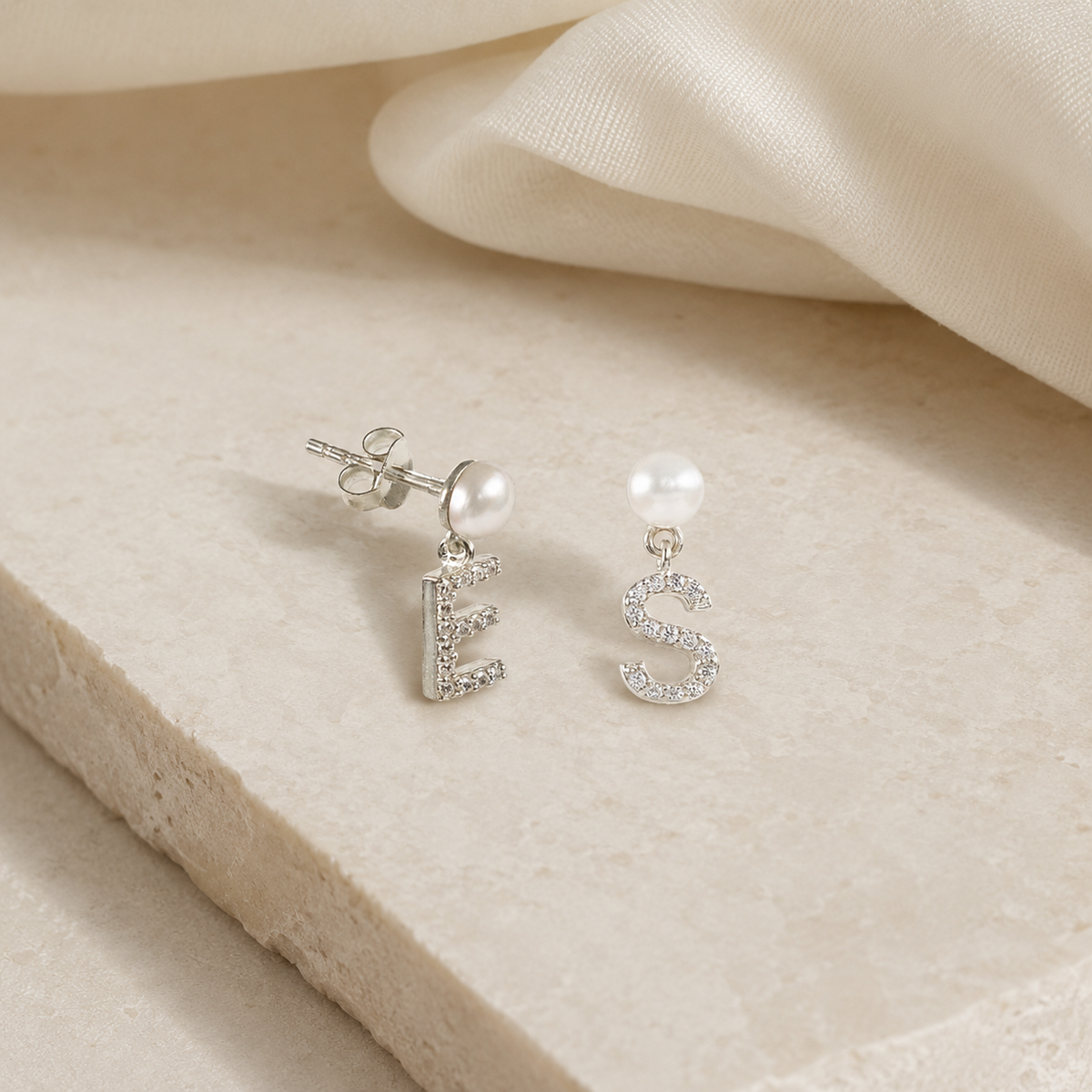 Angle view of personalized pearl CZ initial earrings with a gold-tone finish.