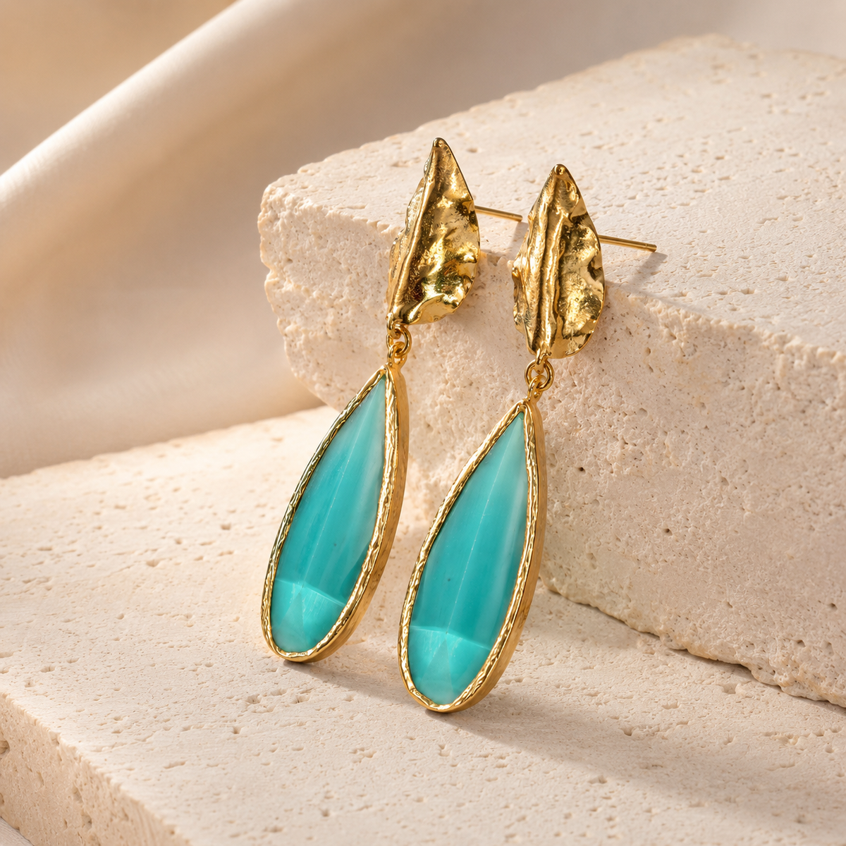 Gold-plated leaf drop earrings shown from a front angle with pine green teardrop accents.