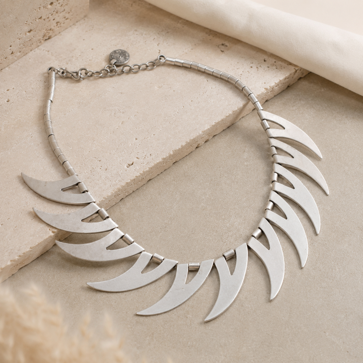 Angled view of the silver-tone crescent spike necklace.
