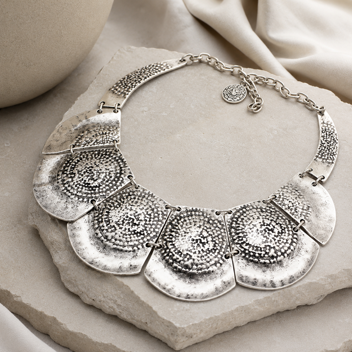 Angle view of the silver hammered plate statement necklace.