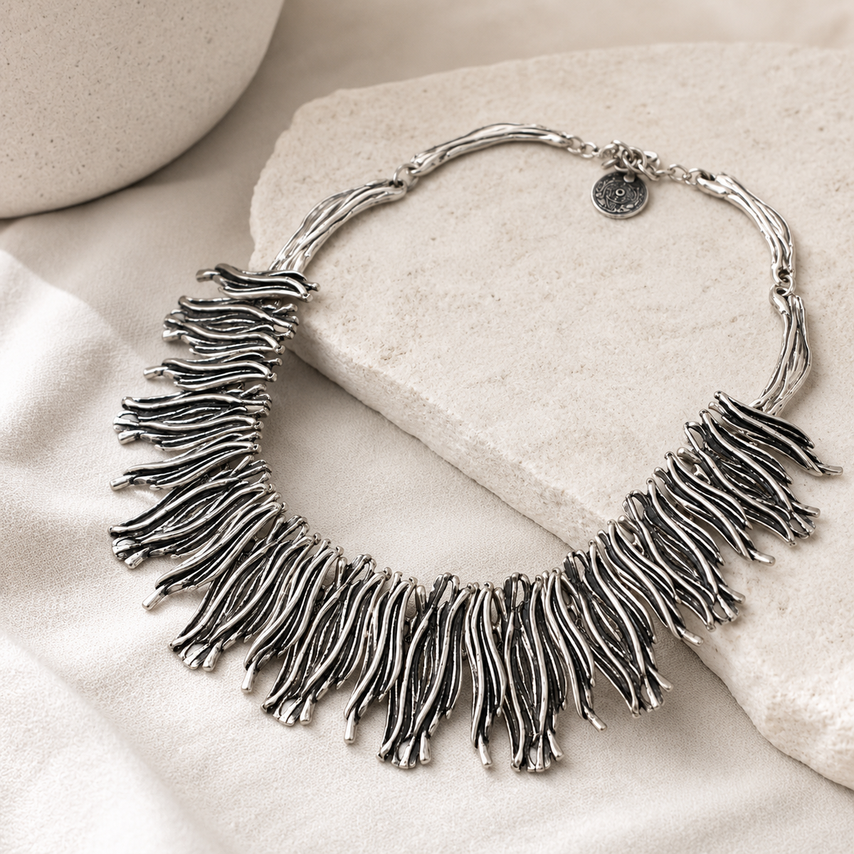 Angled view of the silver-tone fringe collar necklace with flowing strands.