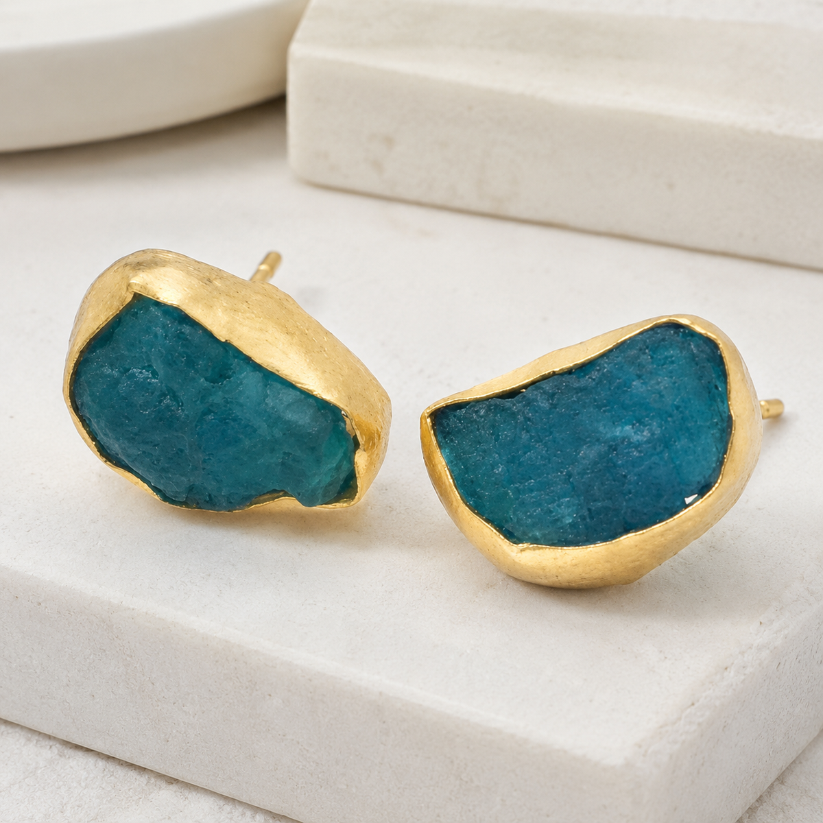 Angled view of rough apatite stud earrings showing the organic stone shape and gold finish.