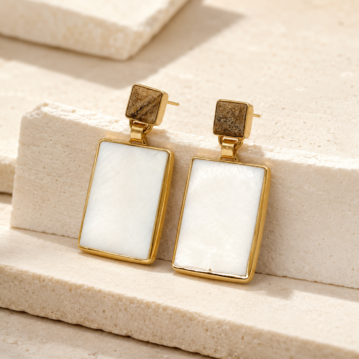 Angle view of heart-shaped black onyx stud earrings with gold-tone trim.