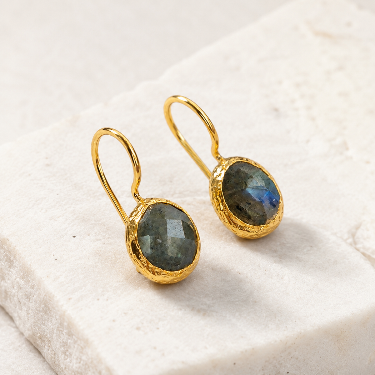 Angled view of gold-plated drop earrings with labradorite stones.