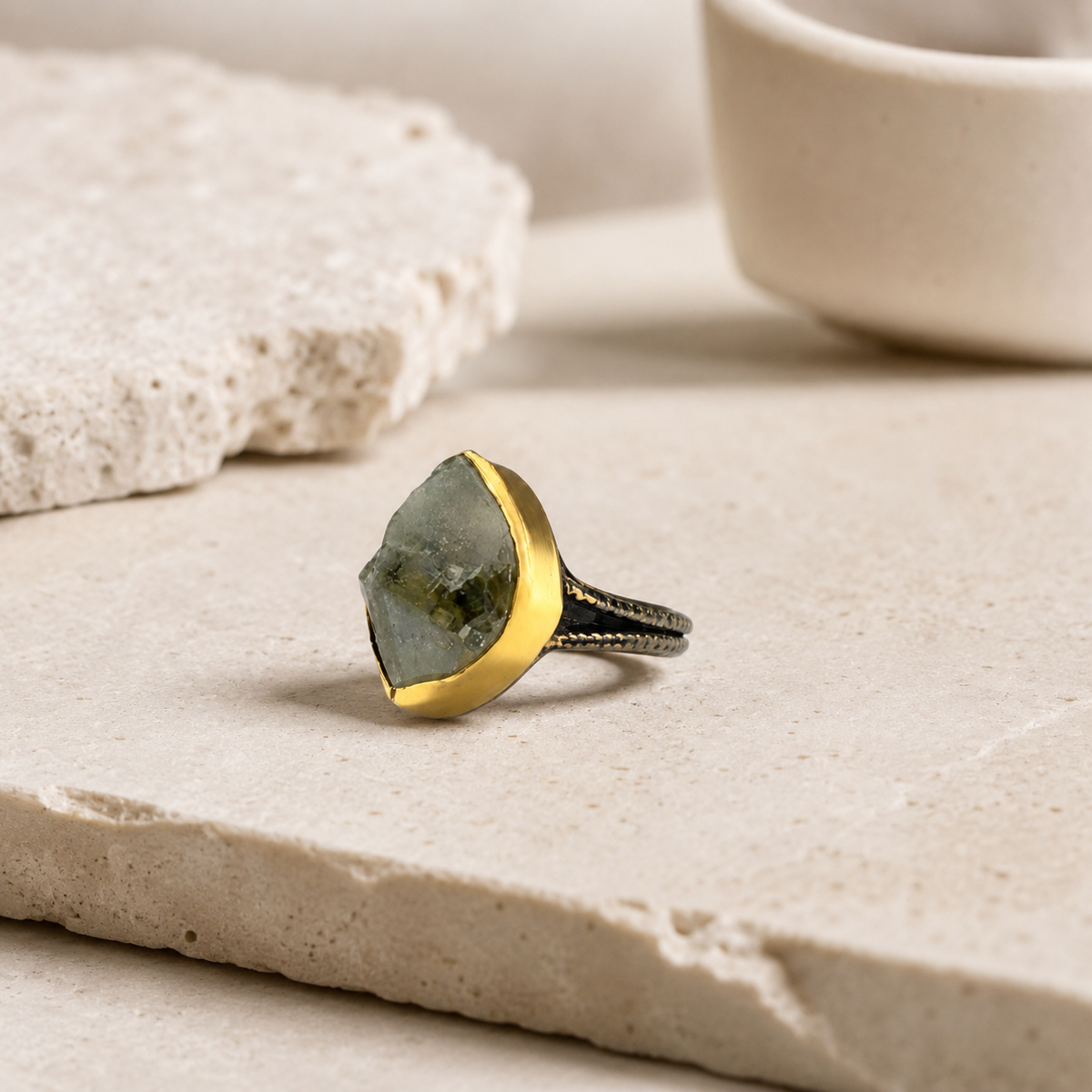 Angled view of a raw green amethyst statement ring with a gold-plated setting.