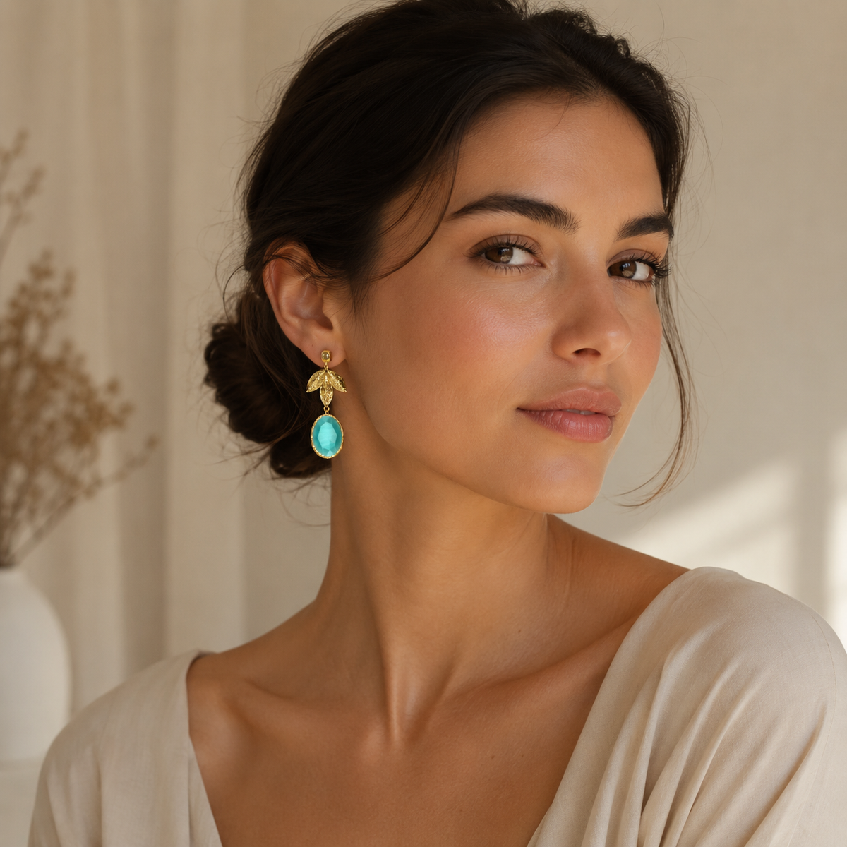 Turquoise leaf drop earrings with a polished gold-tone finish.