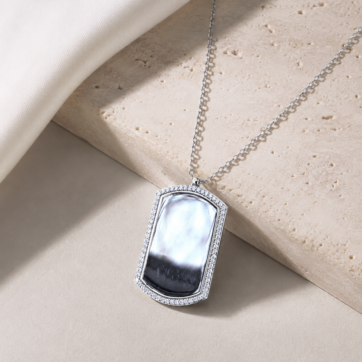 Dog tag pendant necklace with a polished silver-tone finish and slim chain.