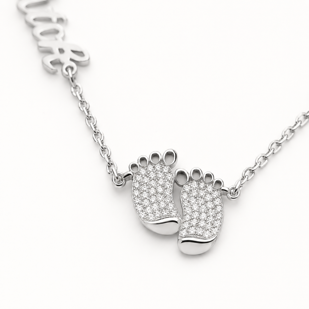 Close view of the baby feet pendant with sparkling detail and engraved names.