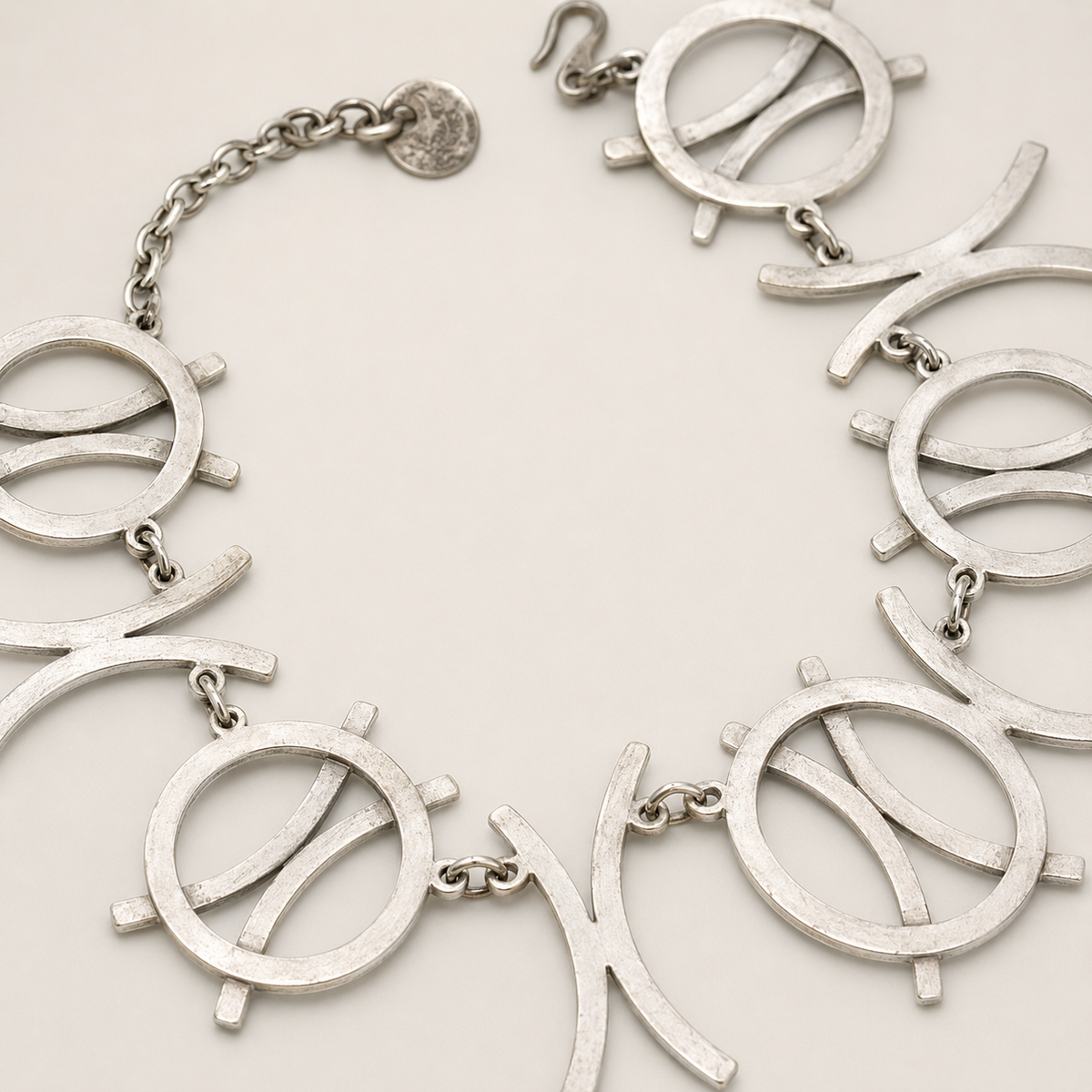 Close view of the silver-tone necklace showing the circle links and curved details.