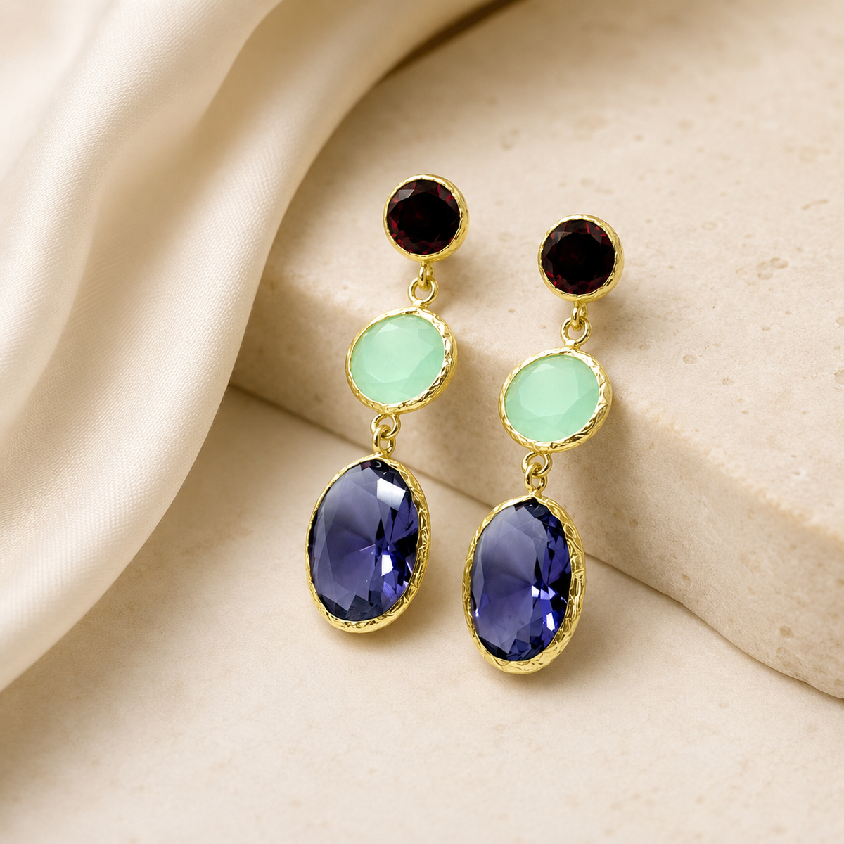 Gold-plated triple drop earrings with colorful faceted stones on a white background.
