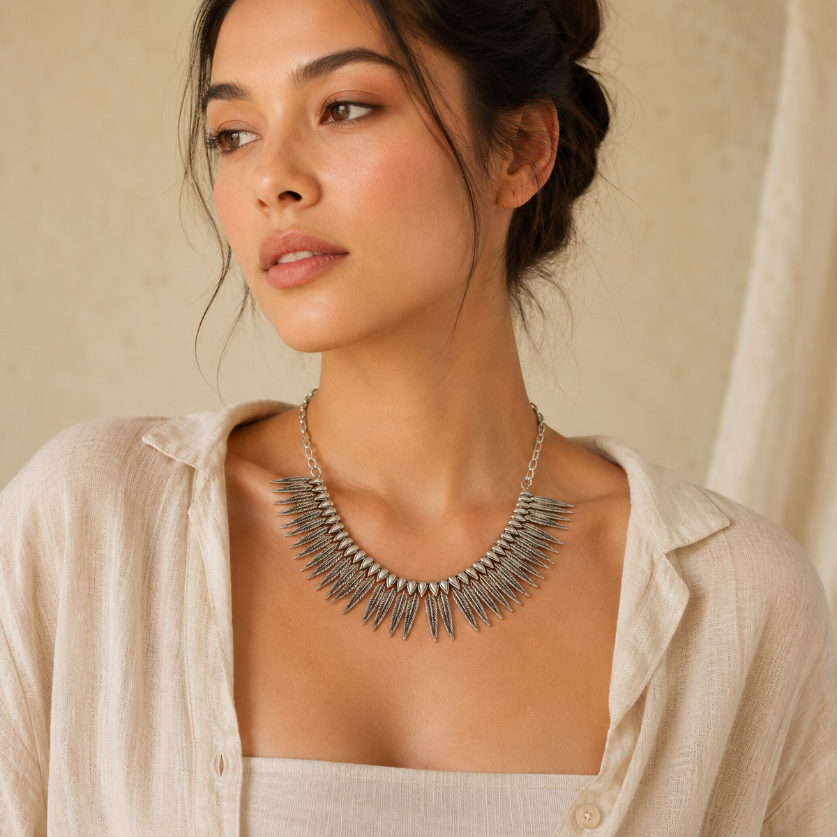 Silver-tone necklace with leaf-inspired spikes and a collar silhouette.
