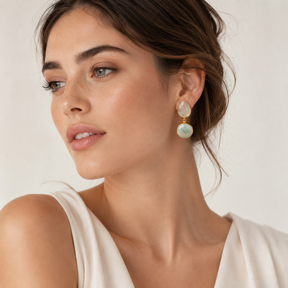 Gold-plated earrings with pale blue-green stones and a soft natural look.