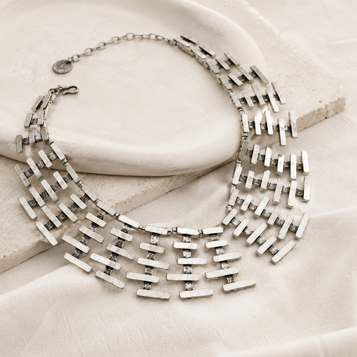 Angled view of a silver-tone bar fringe collar necklace.