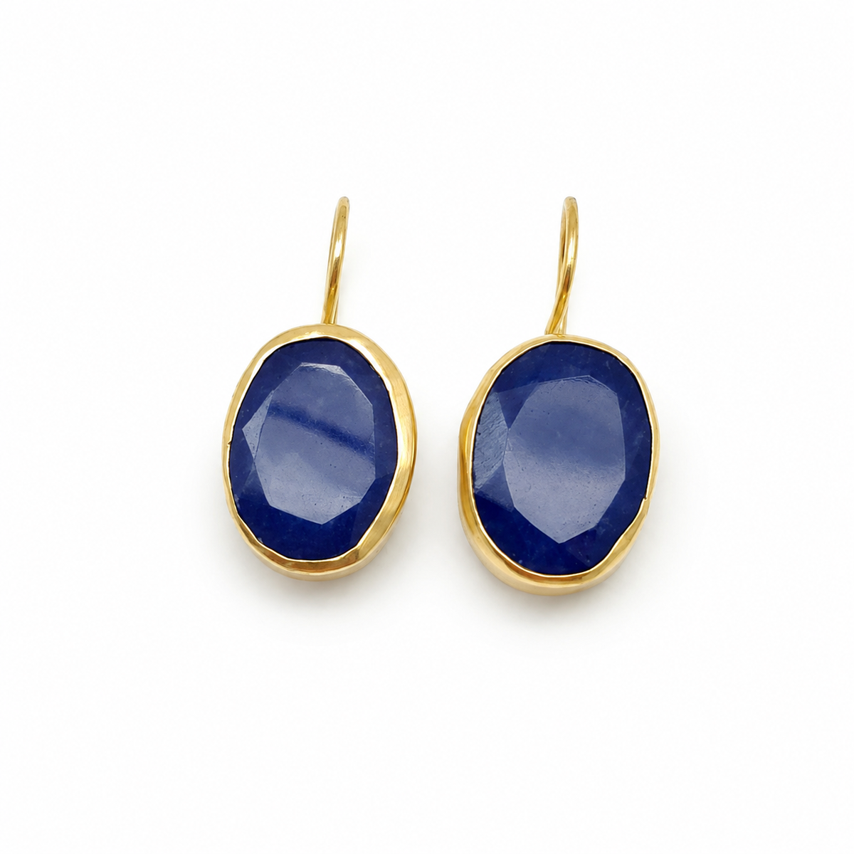 Pair of gold-plated drop earrings with deep blue faceted oval stones.