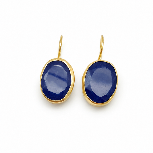 Pair of gold-plated drop earrings with deep blue faceted oval stones.