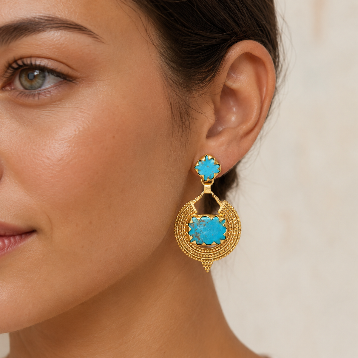 Pair of gold-plated turquoise drop earrings shown front view on a white background.