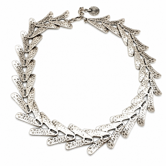 Silver-tone collar necklace with textured arrow-shaped links arranged in a bold circular silhouette.