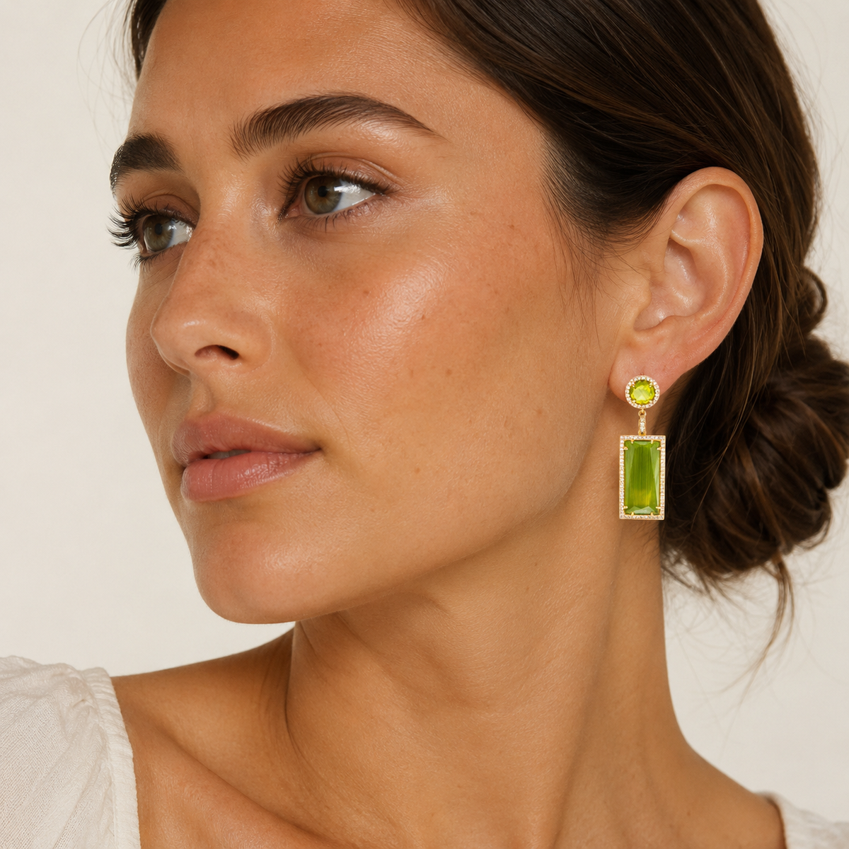 Gold-plated drop earrings with olive green stones and a rectangular dangling shape.