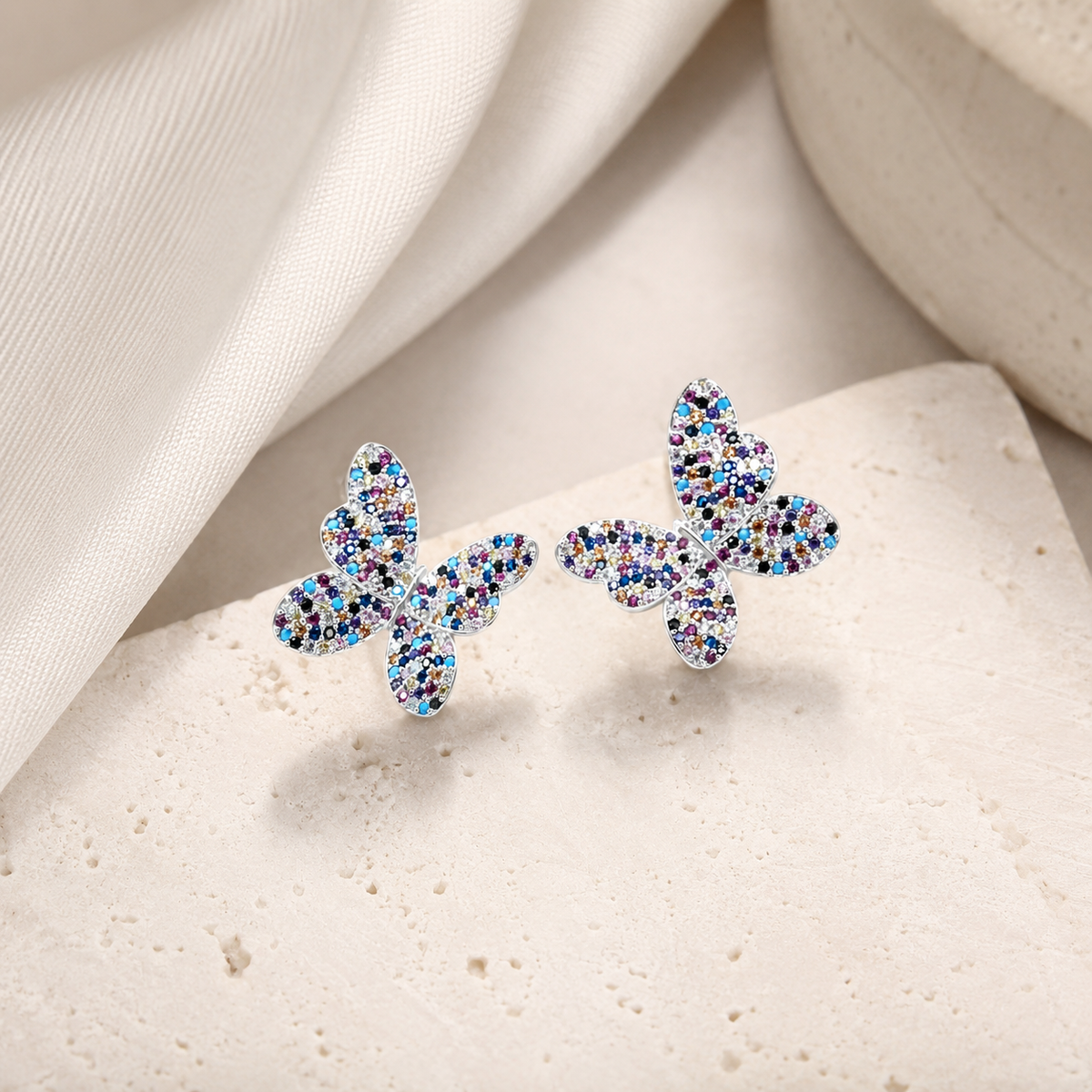 Silver-tone butterfly stud earrings with colorful CZ accents.