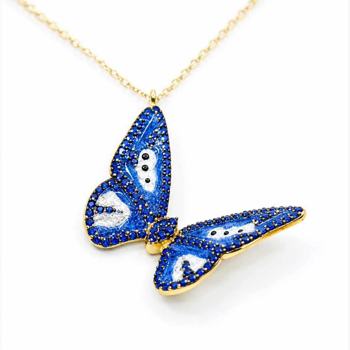Close view of the navy enamel butterfly pendant with gold-tone edges.