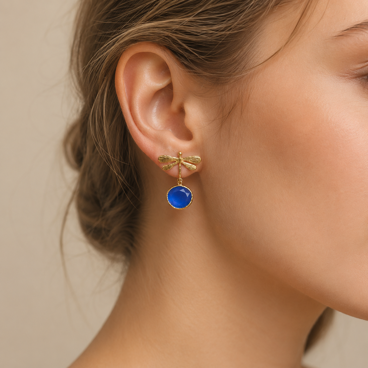 Gold-plated dragonfly earrings shown front view with blue drops.