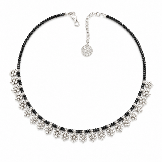 Black bead necklace with floral fringe accents and silver-tone details.