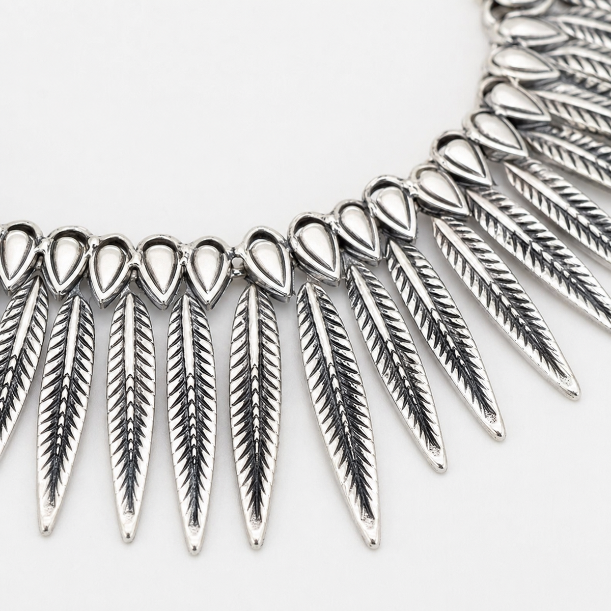 Close view of the textured leaf-like spike details on the necklace.