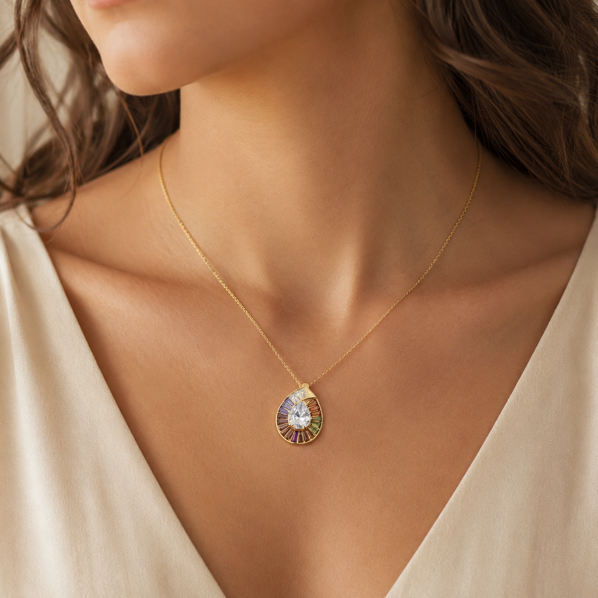 Gold-tone rainbow CZ pendant necklace shown on a white background.