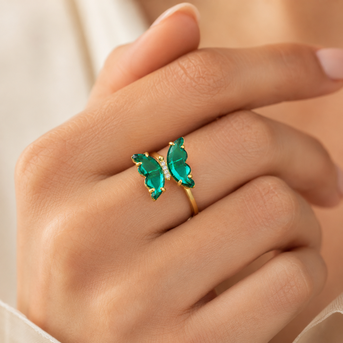 Butterfly ring with crystal-green stones and clear center accents.