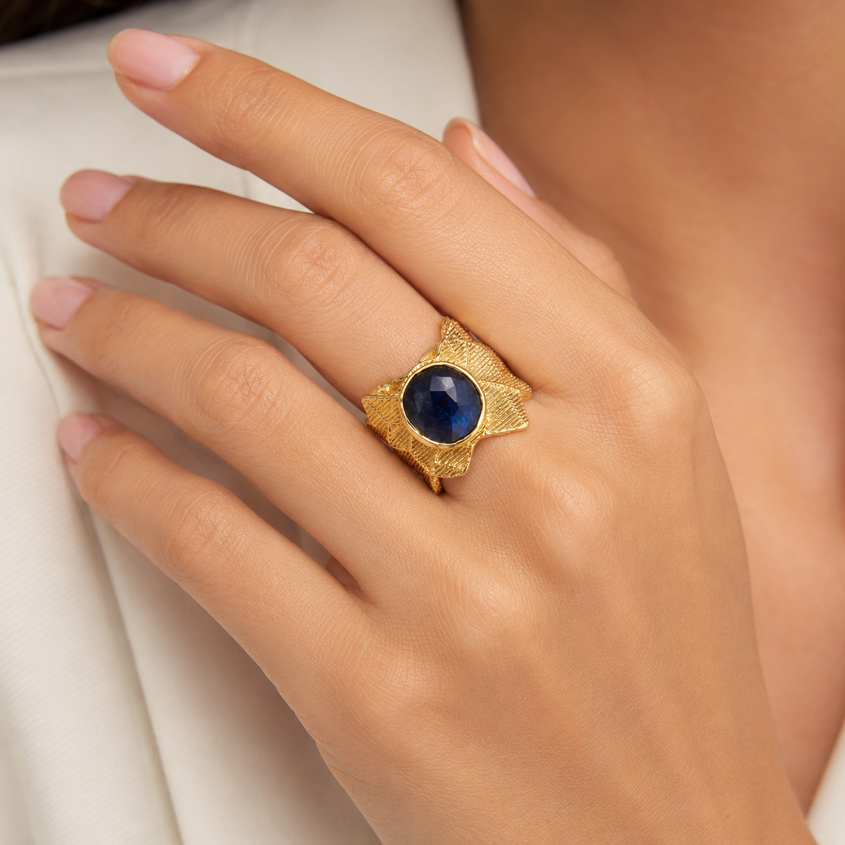 Gold-plated statement ring with a navy blue oval stone shown from the front.