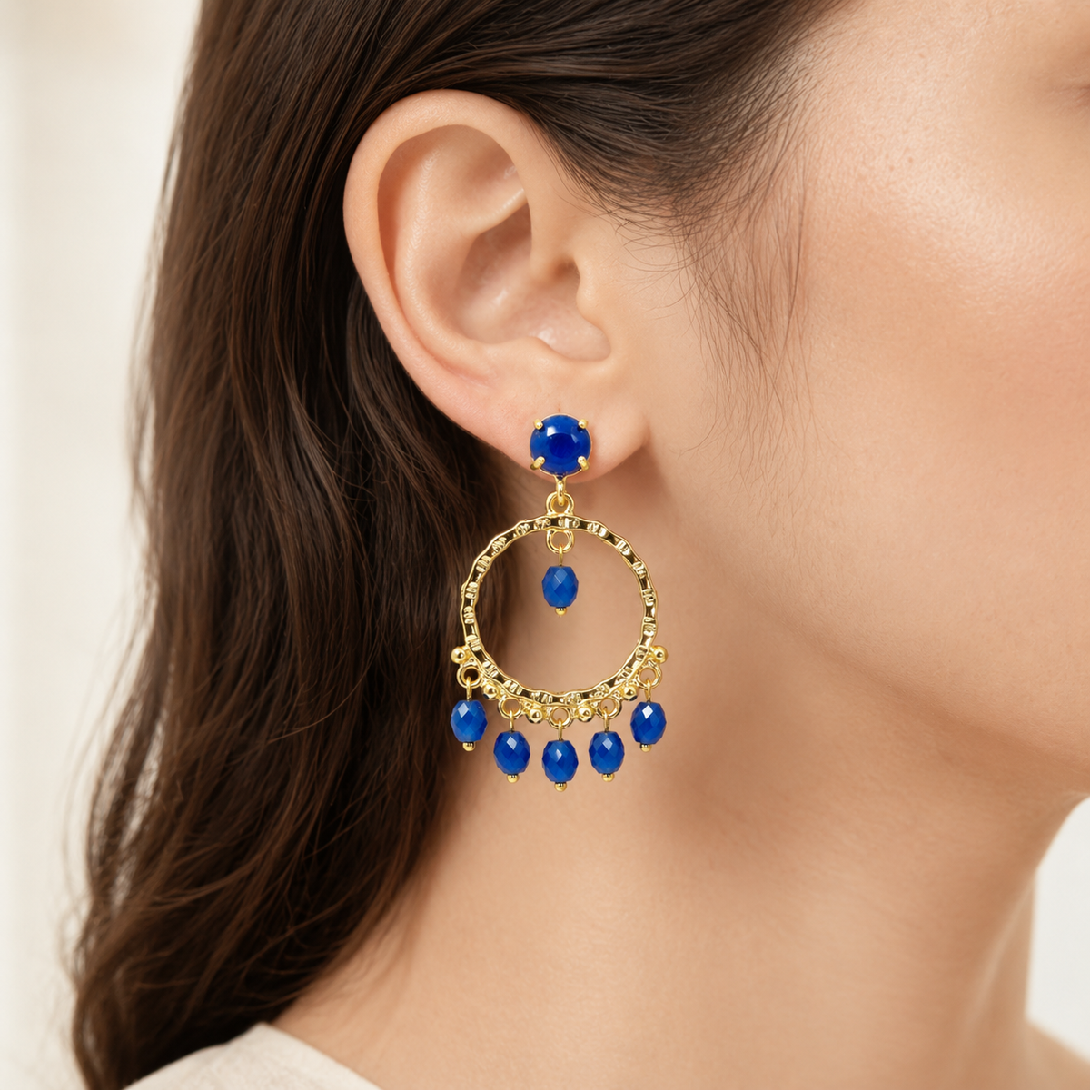 Pair of gold-plated dangle earrings with vivid blue stones.