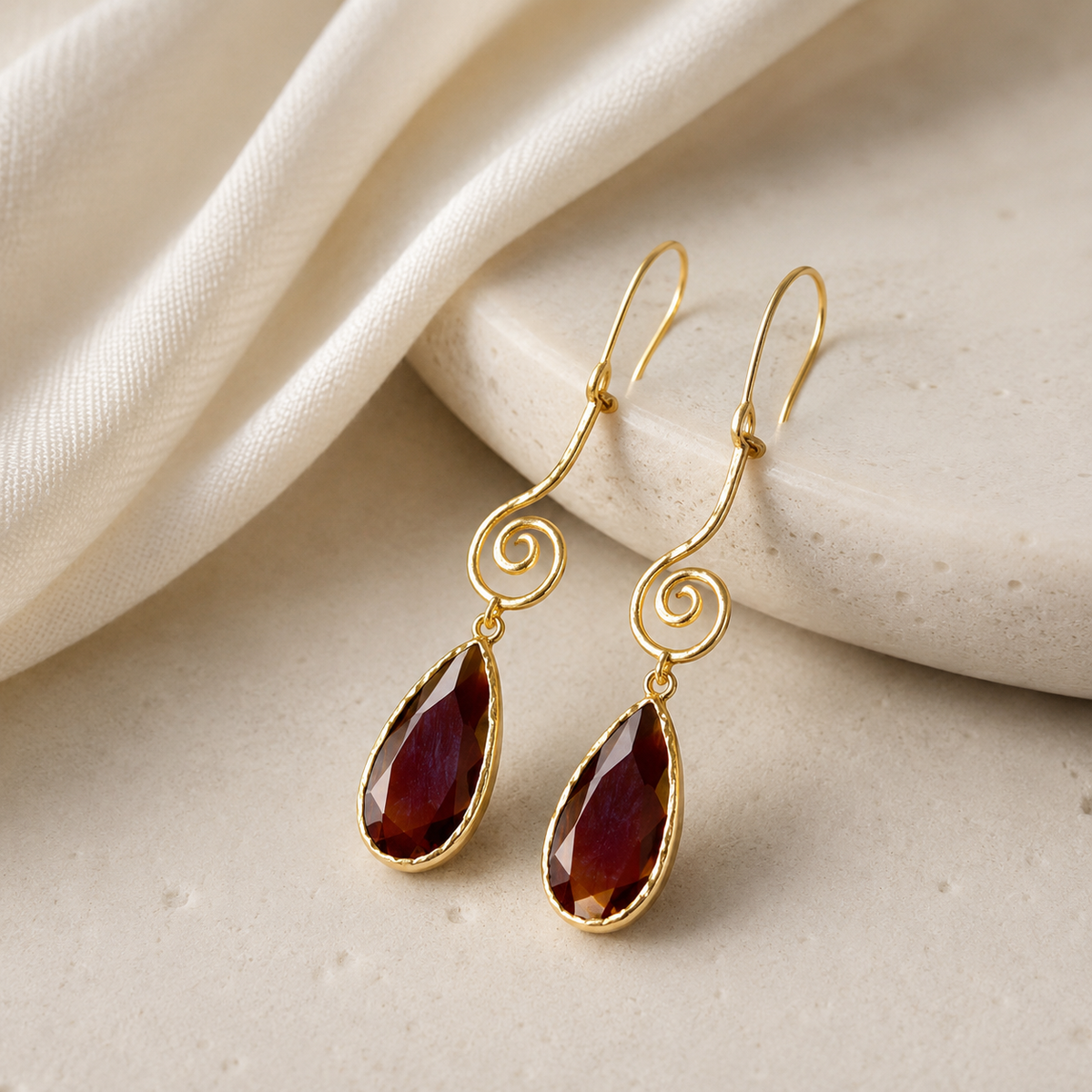Gold-plated drop earrings with a spiral shape and brown teardrop stones.