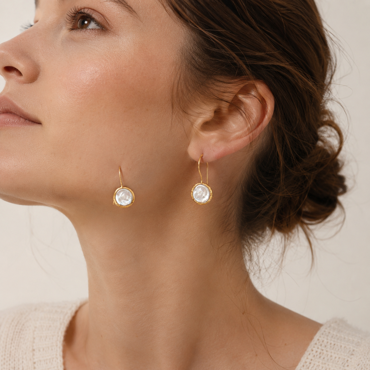Gold-plated drop earrings with coin pearl centers shown from the front.
