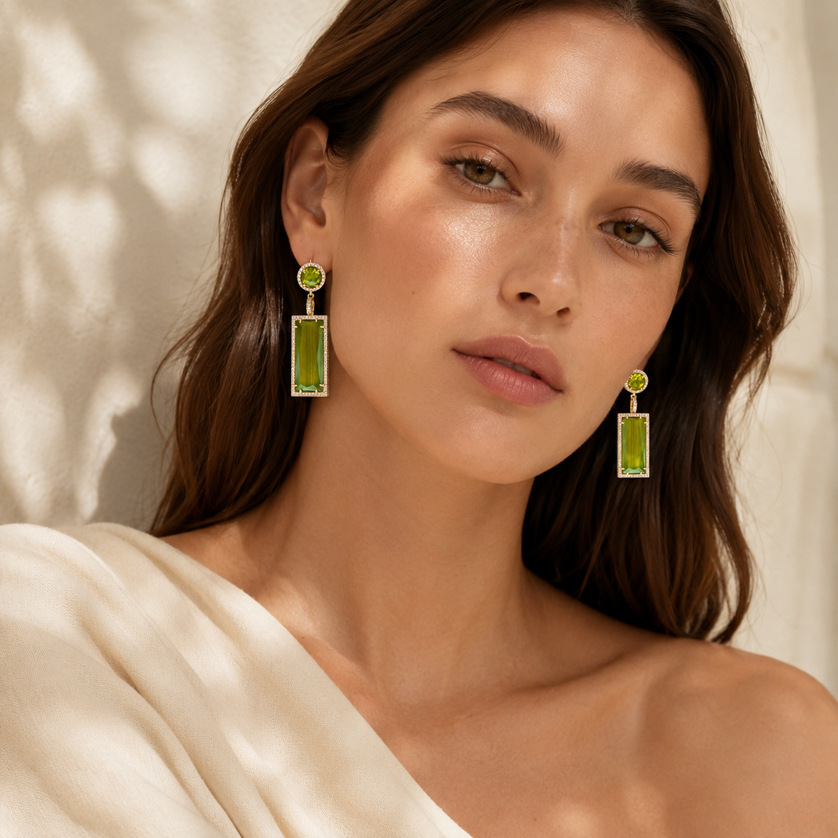 Gold-plated earrings with olive green stone details and sparkling borders.