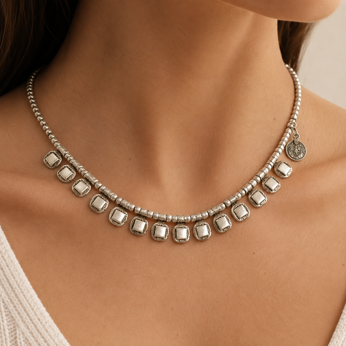 Silver-tone beaded necklace with square drop accents shown front view.