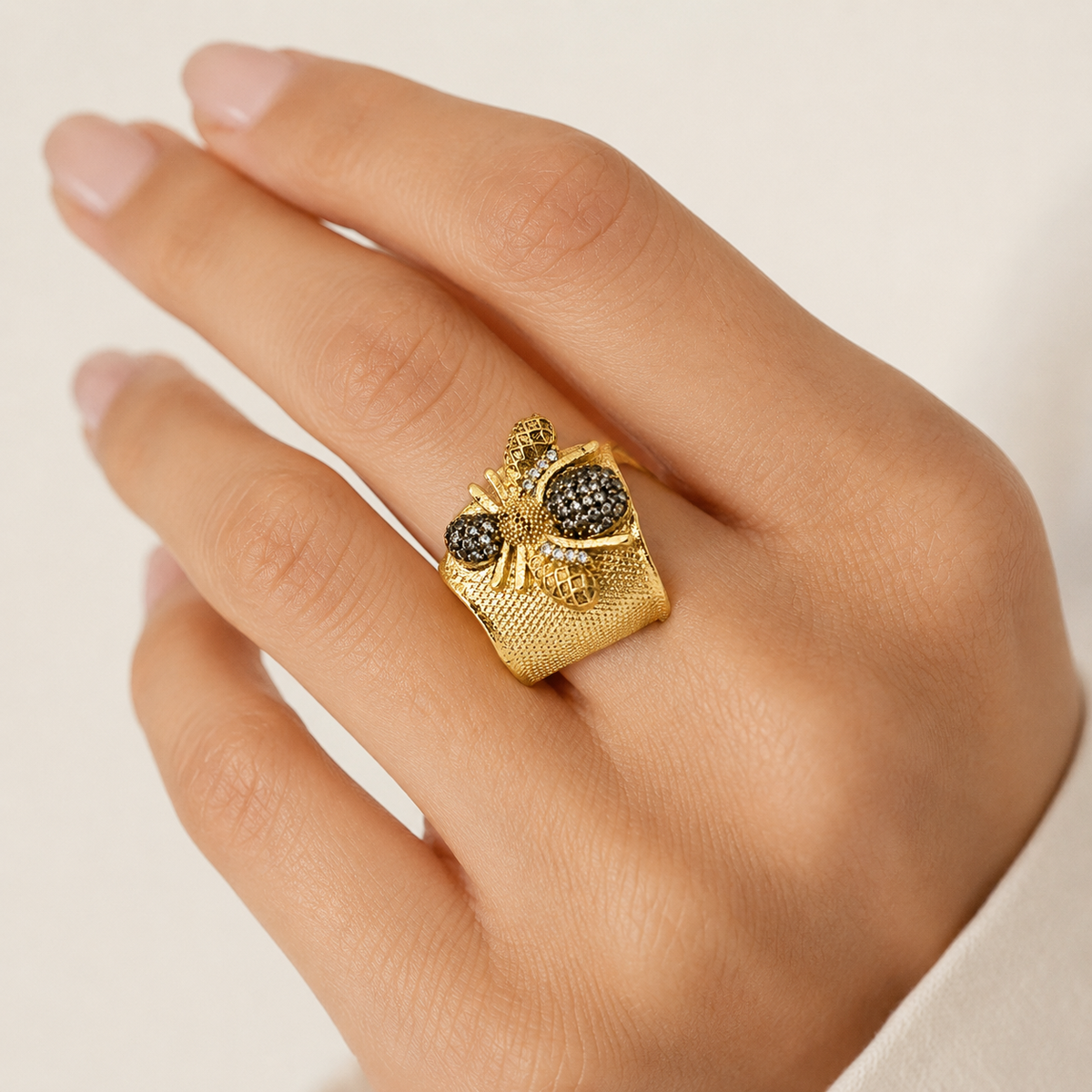 Gold-plated bumble bee cuff ring shown at an angle with textured detailing.