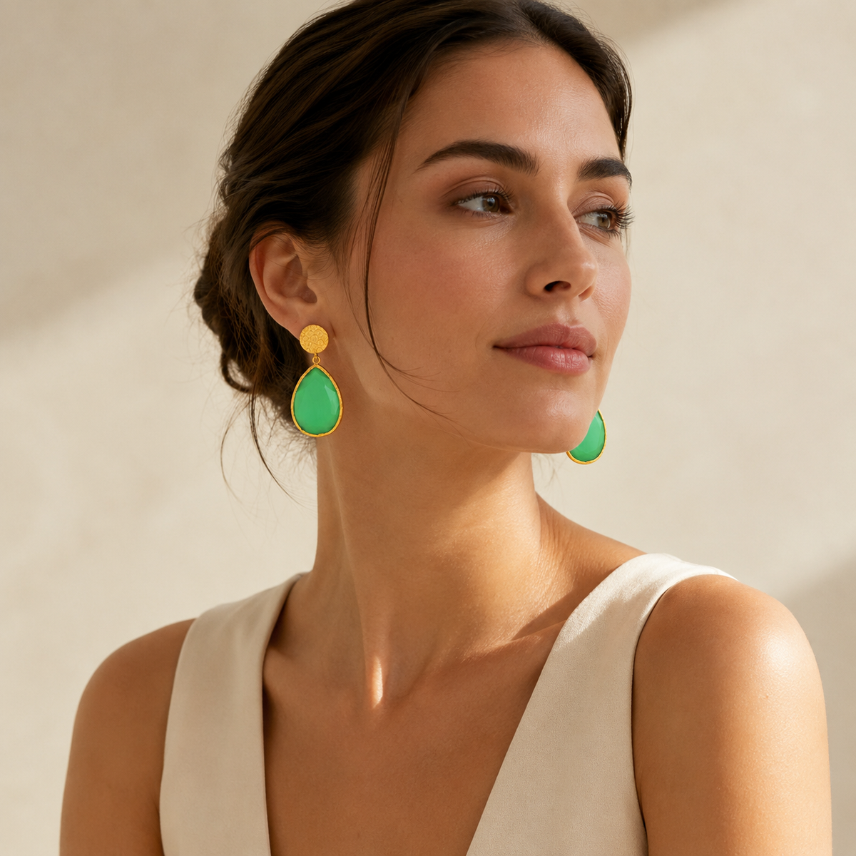 Gold-plated teardrop earrings with a faceted green smoky cat eye-style stone.