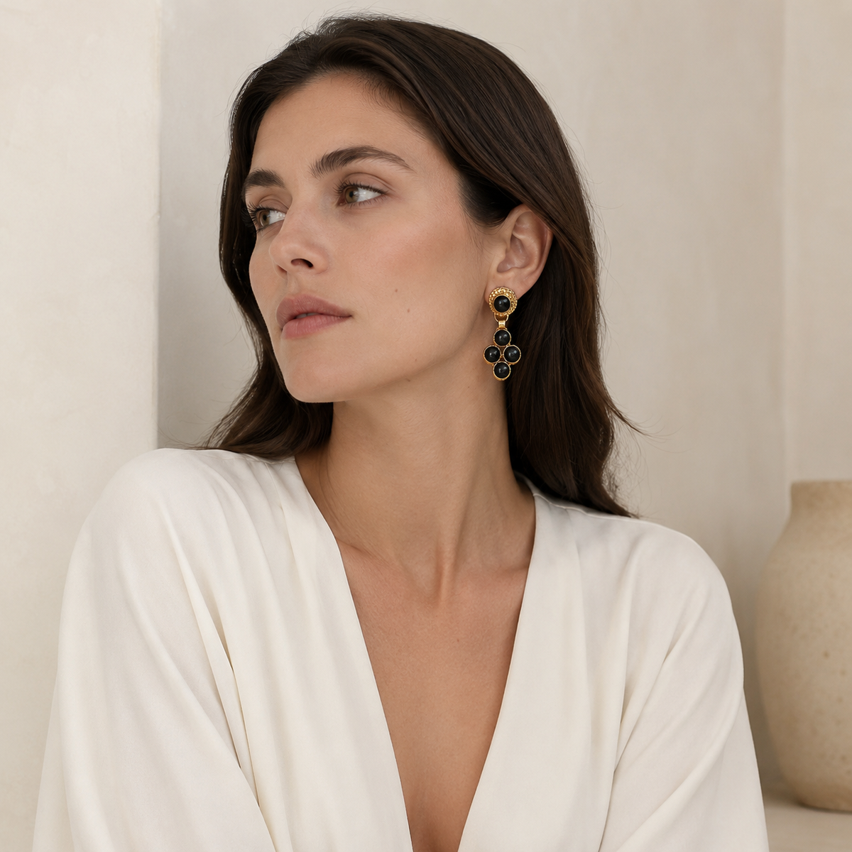 Gold-plated earrings with glossy black stones and a layered drop design.
