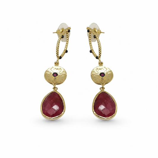 Long gold-plated statement earrings with textured drop links and deep red faceted pendants.