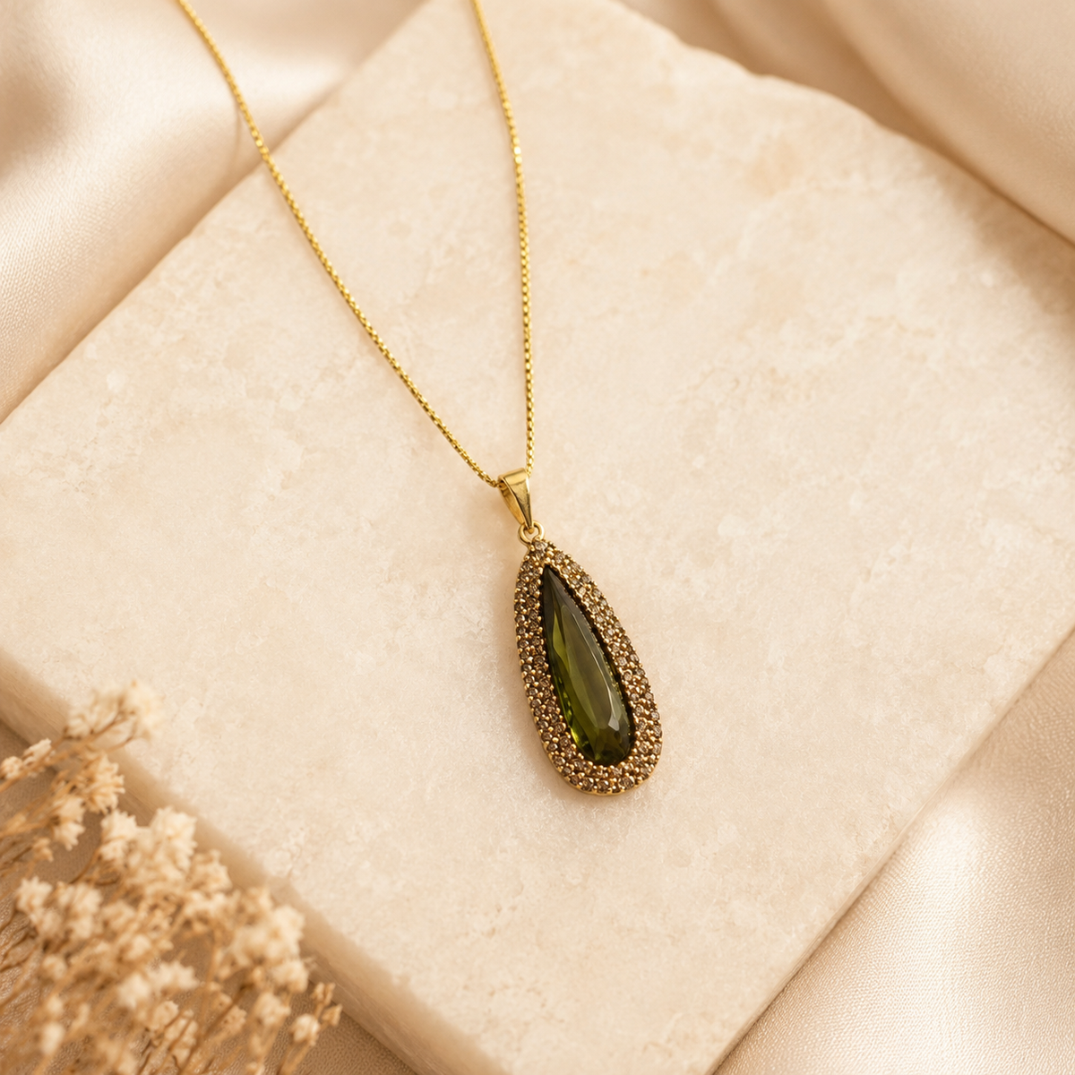 Gold-tone necklace with a slender teardrop pendant.