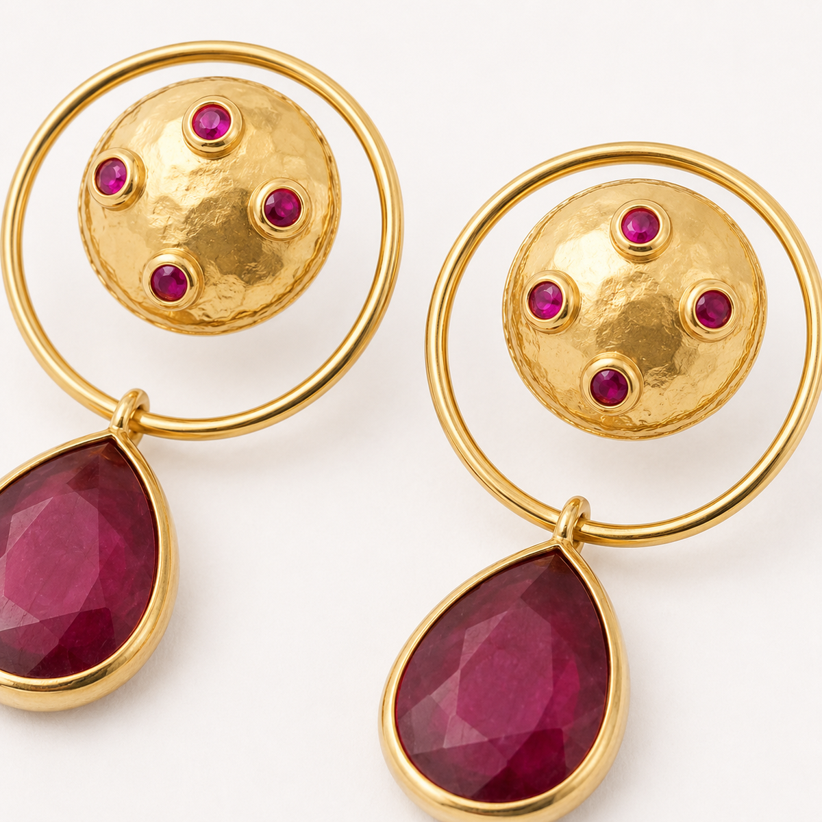 Gold-plated dangle earrings with a circular top, magenta accents, and a teardrop drop.