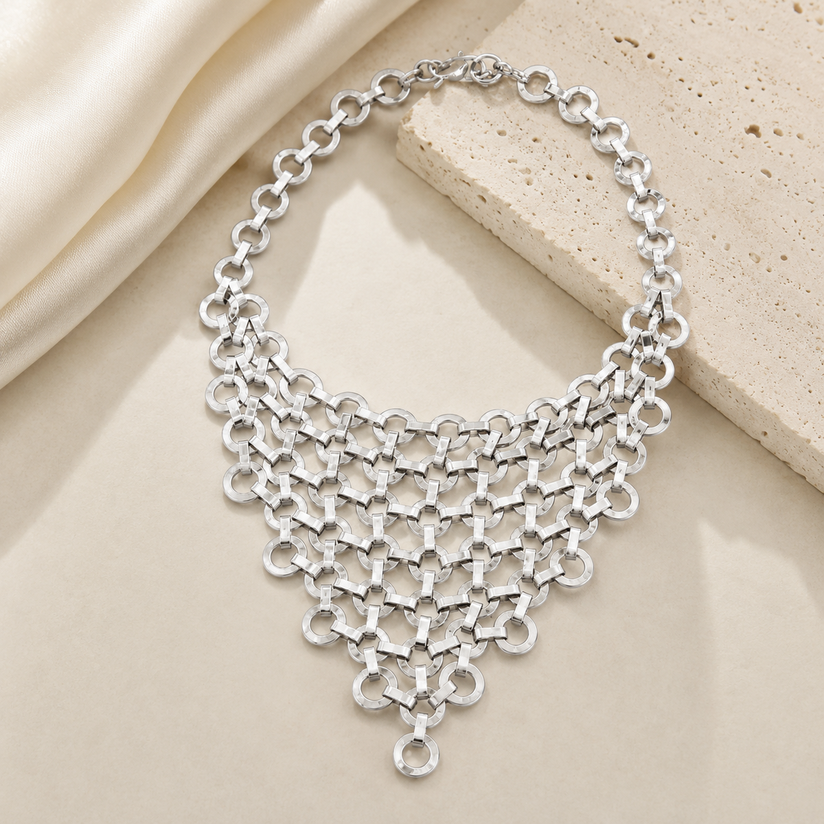 Silver-tone statement necklace with a sculptural bib silhouette.
