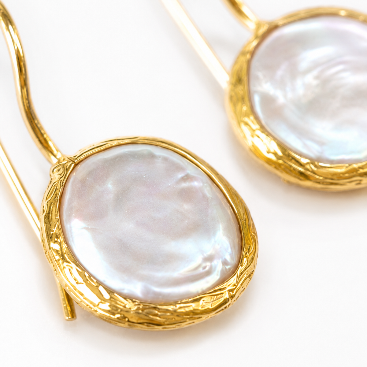 Close view of coin pearl drop earrings with a gold-plated frame.