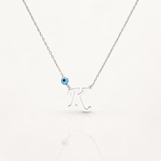 Silver-tone necklace with a personalized initial pendant and small blue evil eye accent.