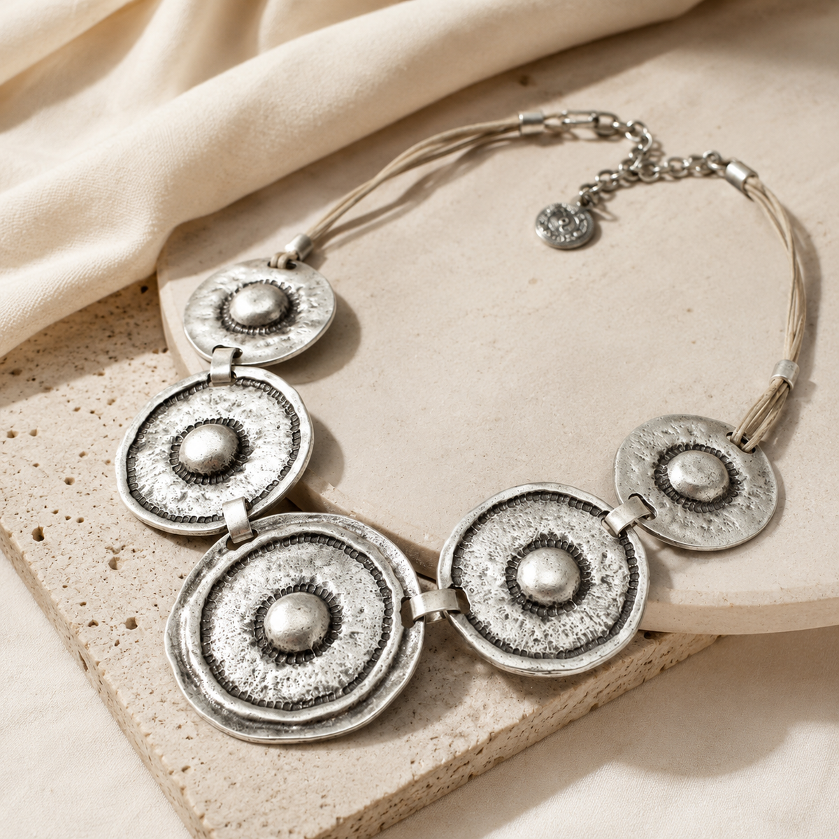 Angled view of the hammered silver-tone circle statement necklace.