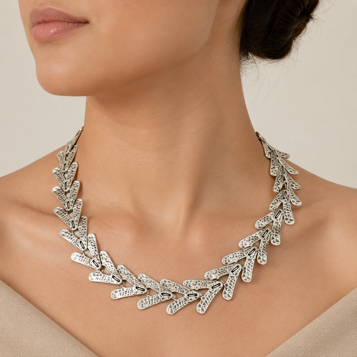 Silver-tone arrow link collar necklace shown on a model.