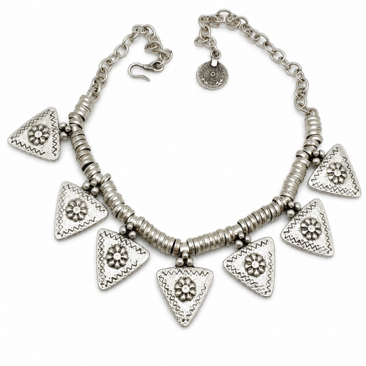 Silver-tone necklace with triangle flower charms and textured links on a white background.
