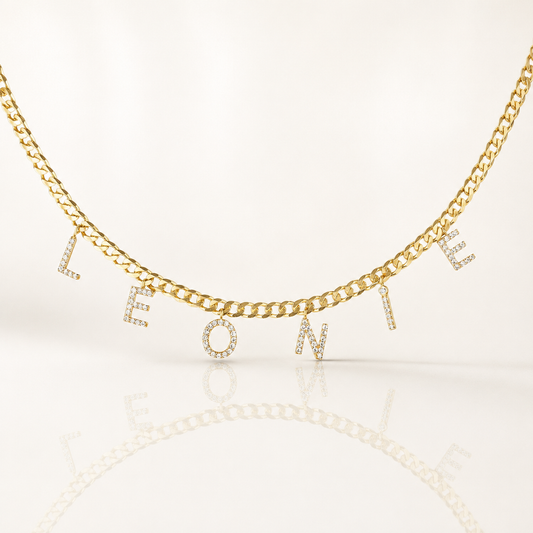 Gold-tone curb chain necklace with CZ letter charms spelling a personalized name.